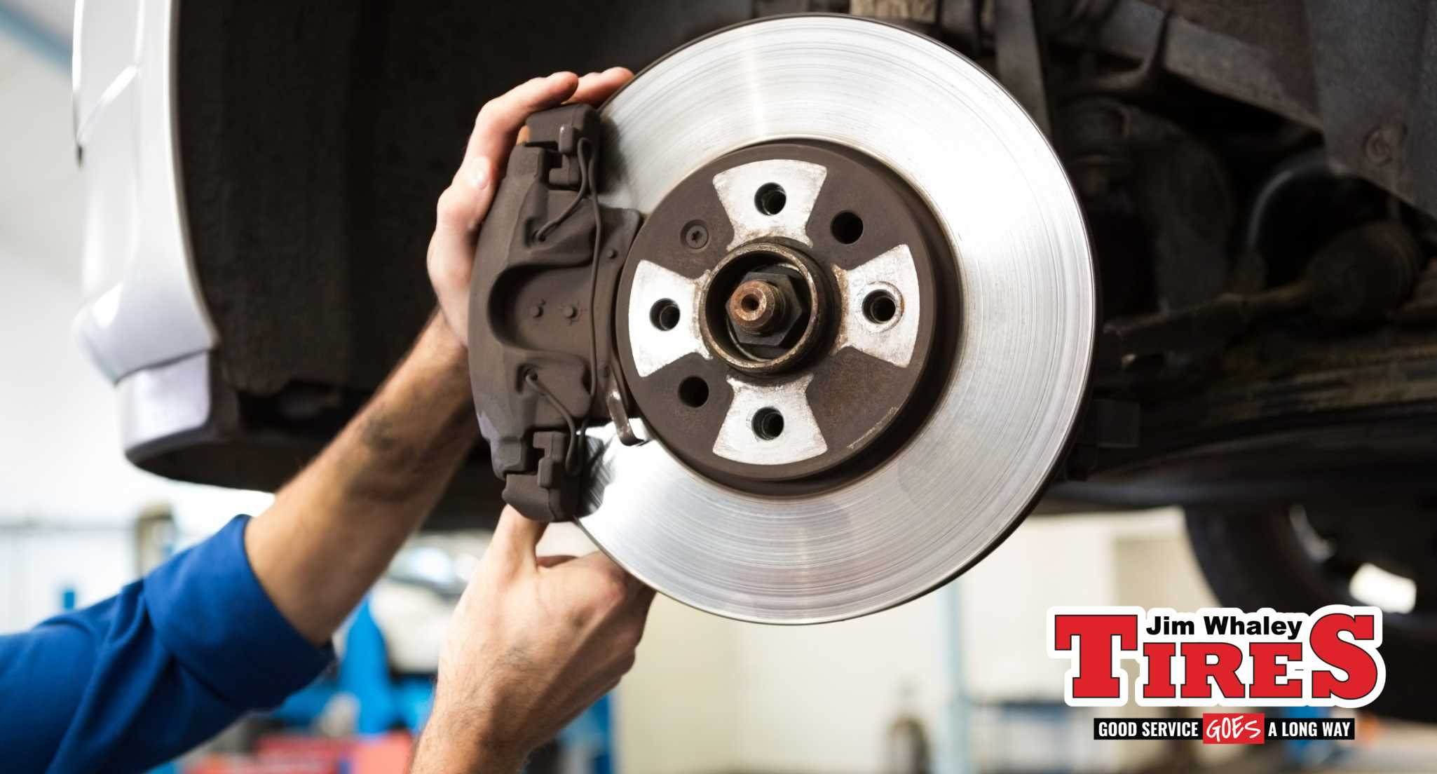 Jim Whaley Tires technician inspecting brake pads on a car in Troy AL