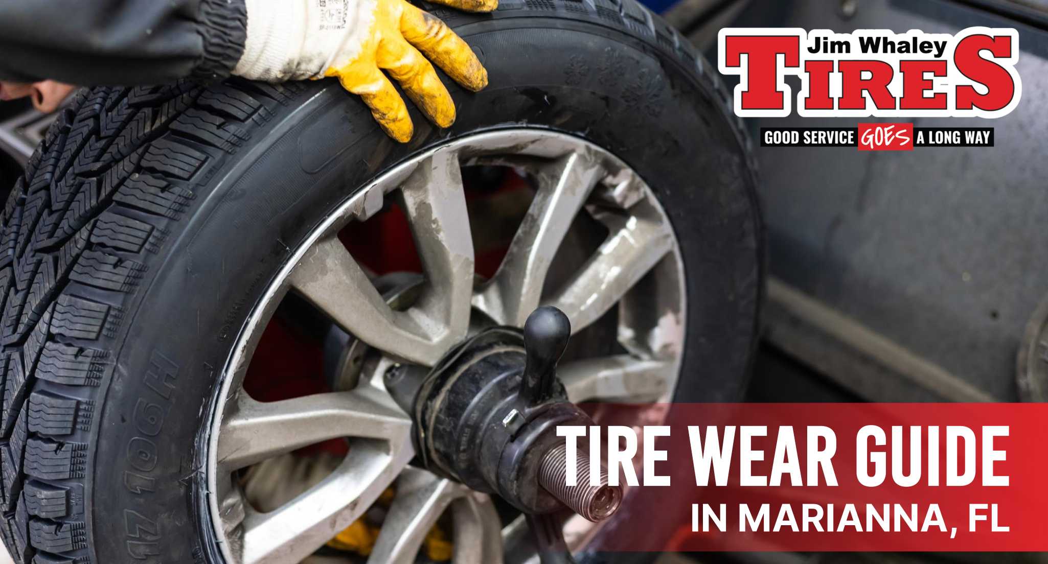 Mechanic inspecting worn tire tread in Marianna FL shop