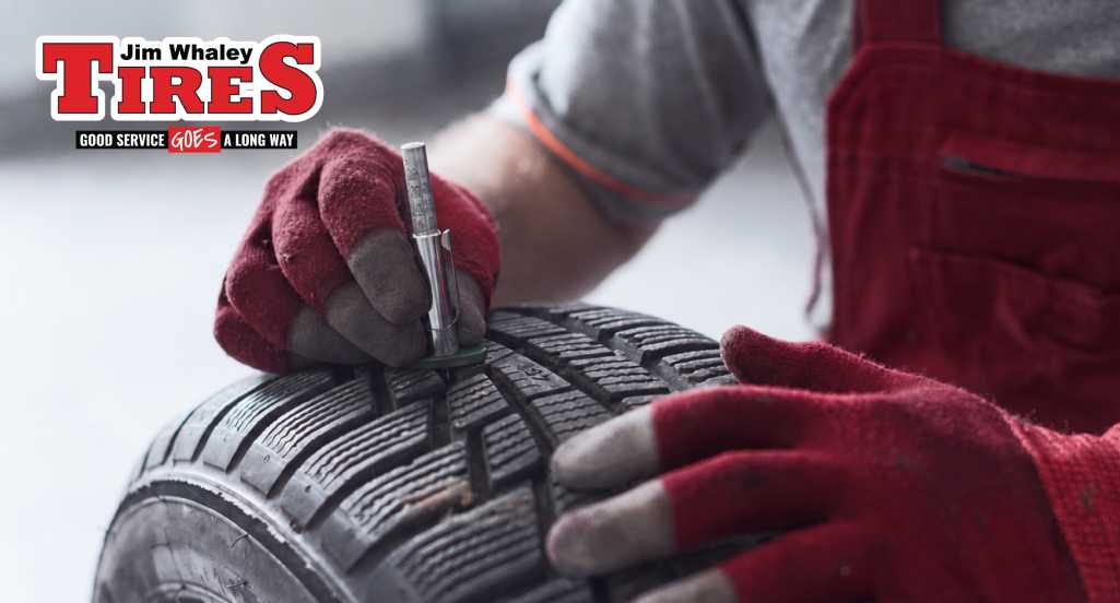 Mechanic checking tire tread and condition at Jim Whaley Tires
